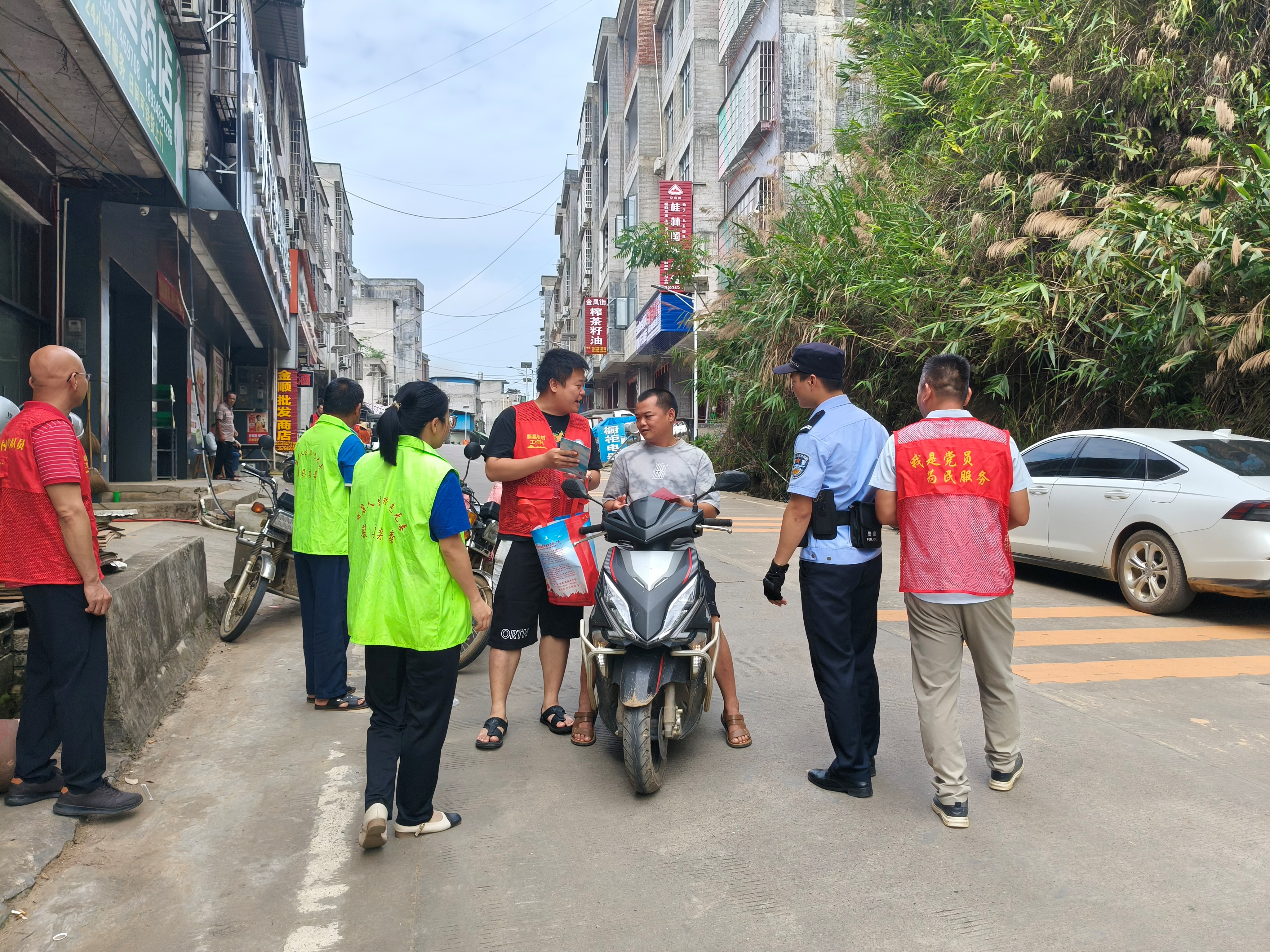 工作队员杨杰正拿着新型毒品识别图向村民张叔讲解.jpg